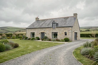 Maison individuelle bretonne en pierre de granit avec jardin soigné dans le Finistère, représentant les constructeurs locaux du top 10 2026